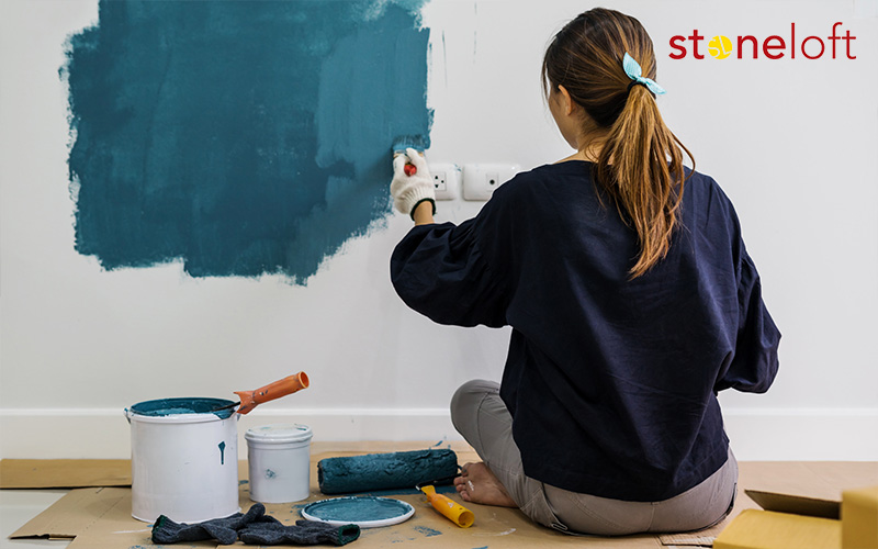 Woman painting her home walls